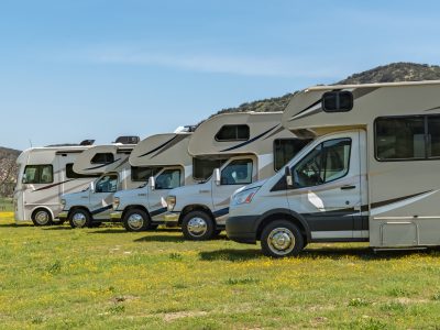 Different sizes of RVs in a line-up from smaller Class C, bigger Class C to a Class A motorhome in an outdoor setting